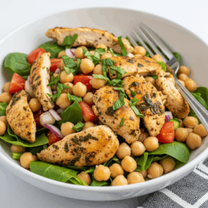 Healthy grilled chicken and chickpea salad with spinach, cherry tomatoes, and red onion — a protein-packed, easy meal prep recipe perfect for clean eating or a light lunch.